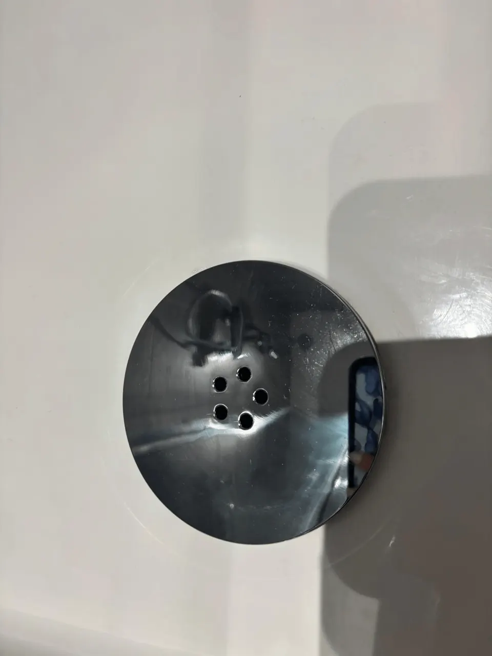 The same shower drain cover cleaned and polished