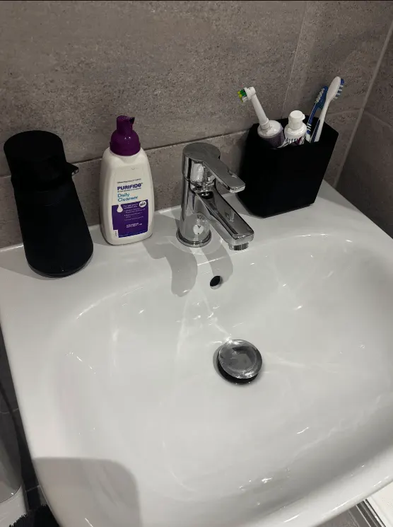 White bathroom basin and chrome tap after cleaning