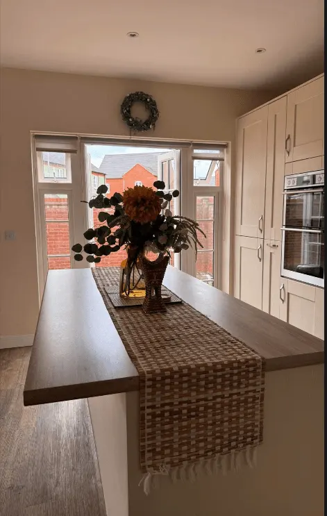 Kitchen with wooden island and fitted units after a clean