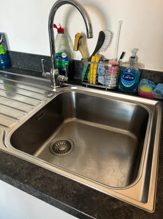 Stainless steel kitchen sink and mixer tap cleaned to a shine
