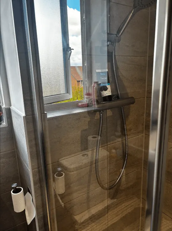 Shower enclosure with clear glass and chrome fittings after cleaning