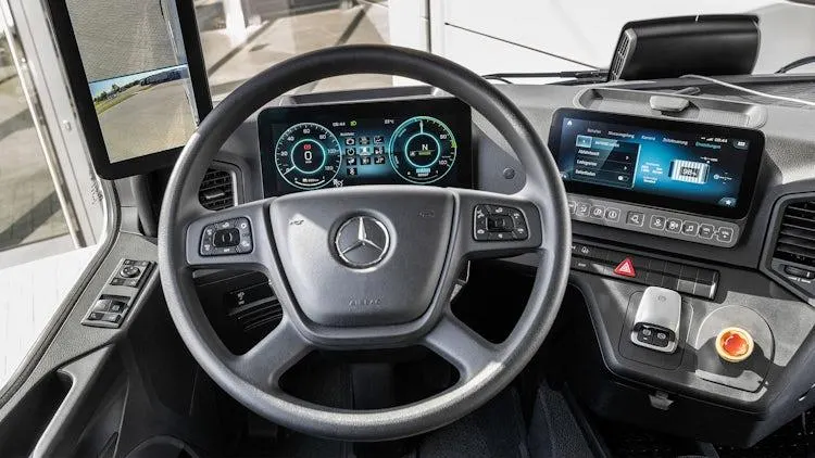 Clean HGV cab interior with steering wheel and dashboard screens